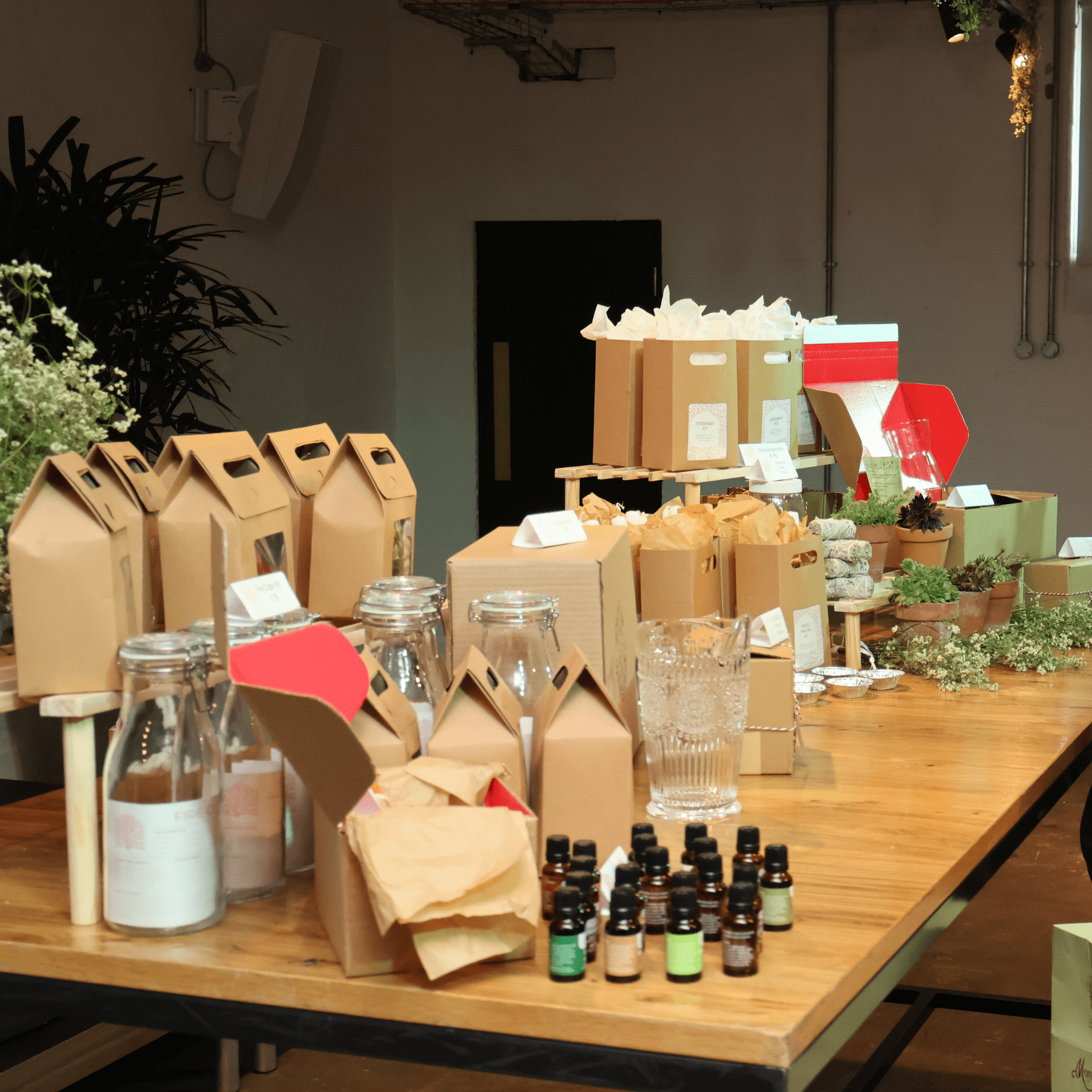 a trestle table set up for a creative workshop including plants and essential oils