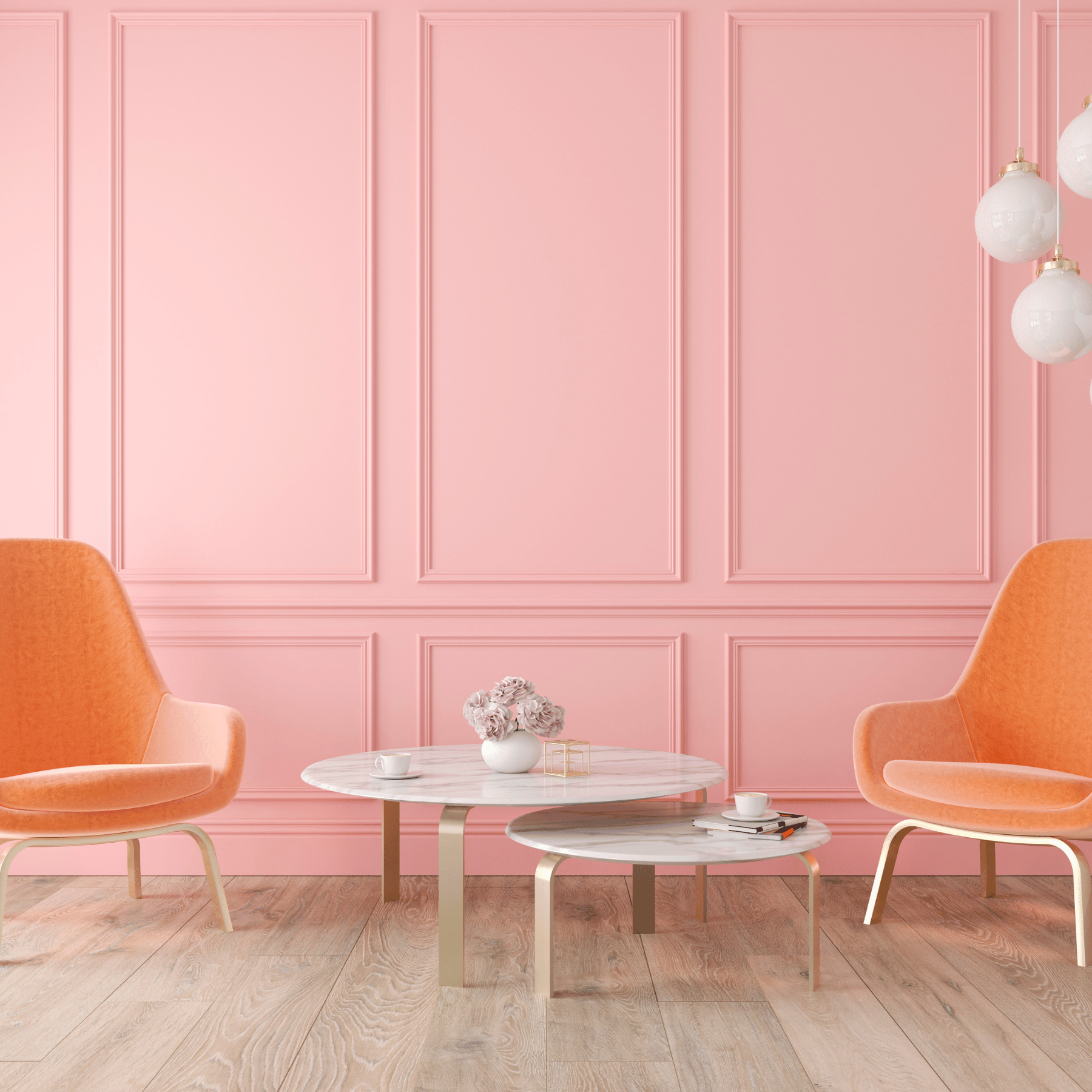 two velvet orange chairs next to two white and gold round marble coffee tables against a pale pink panelled wall